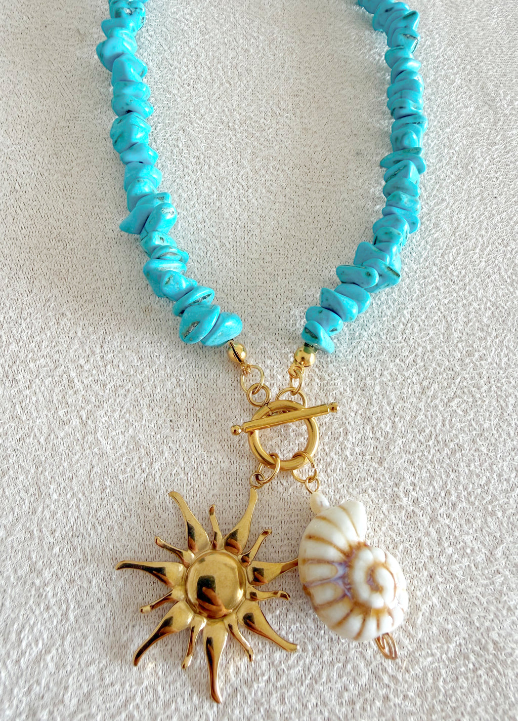 Coral en turquesa, sol y concha marina